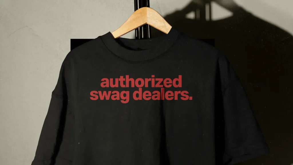 black t-shirt with red text “authorized swag dealers” representing branded merchandise and tour swag strategy | Swag vs Merch